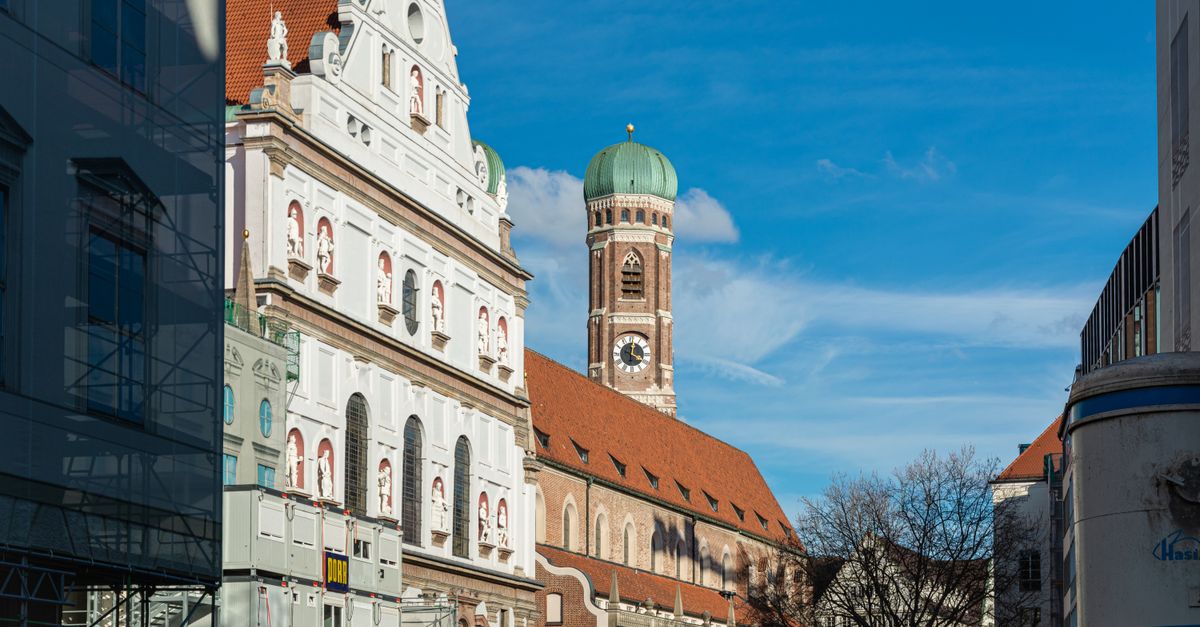 Capture of St. Michael's Church and Frauenkirche tower in Munich, Germany, under a clear blue sky.